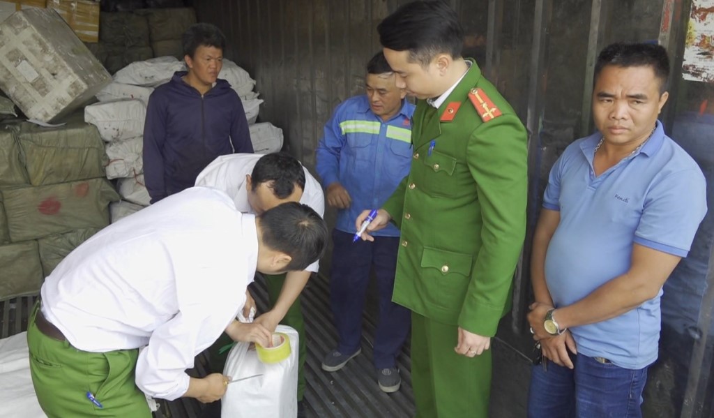 Nguyễn Văn Chiến (ngoài cùng bên phải) cùng số hàng hoá bị thu giữ