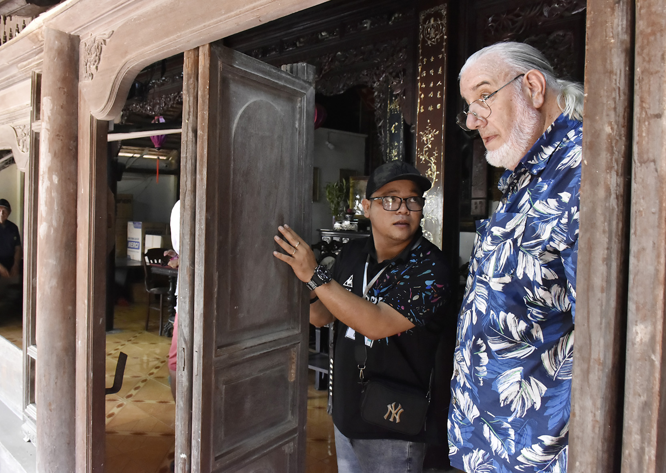 Một du khách tìm hiểu kỹ kiến trúc, chất liệu gỗ, cách lắp ghép các cánh cửa của nhà cổ Nguyễn Hoàng (hẻm 341 Võ Thị Sáu, TT.Long Điền).