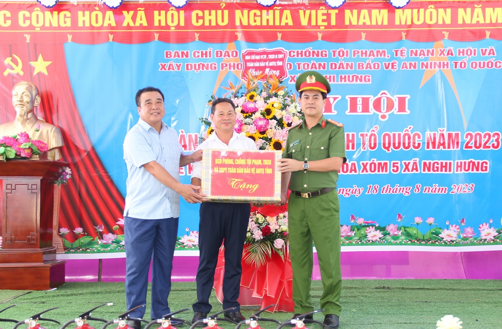 Đồng chí Đại tá Nguyễn Đức Hải, Phó Giám đốc Công an tỉnh trao quà tặng chính quyền và bà con Nhân dân xã Nghi Hưng