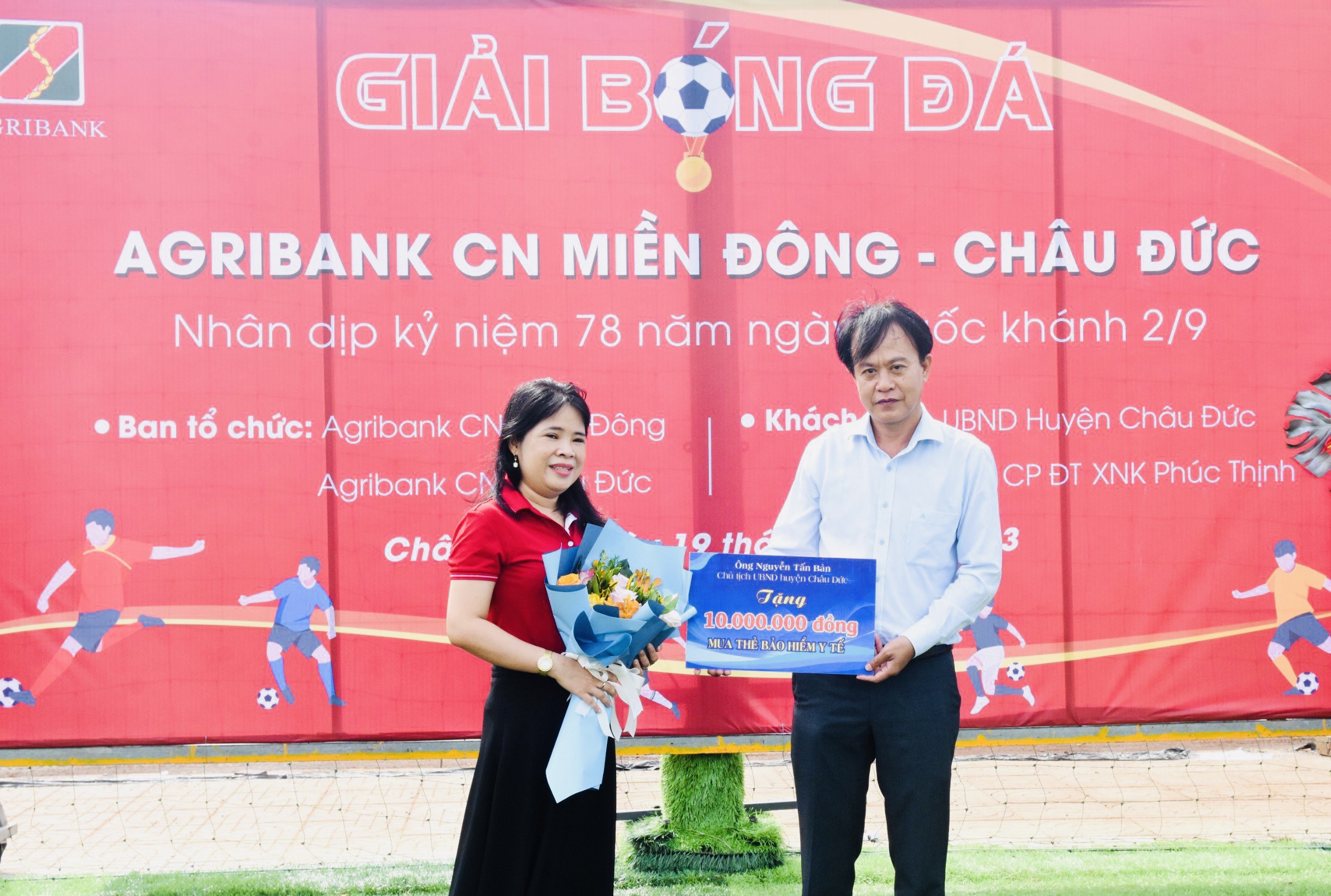 Đại diện của ông Nguyễn Tấn Bản, Chủ tịch UBND huyện Châu Đức trao bảng tượng trưng số tiền 10 triệu đồng mua thẻ bảo hiện cho người nghèo xã Cù Bị, huyện Châu Đức.