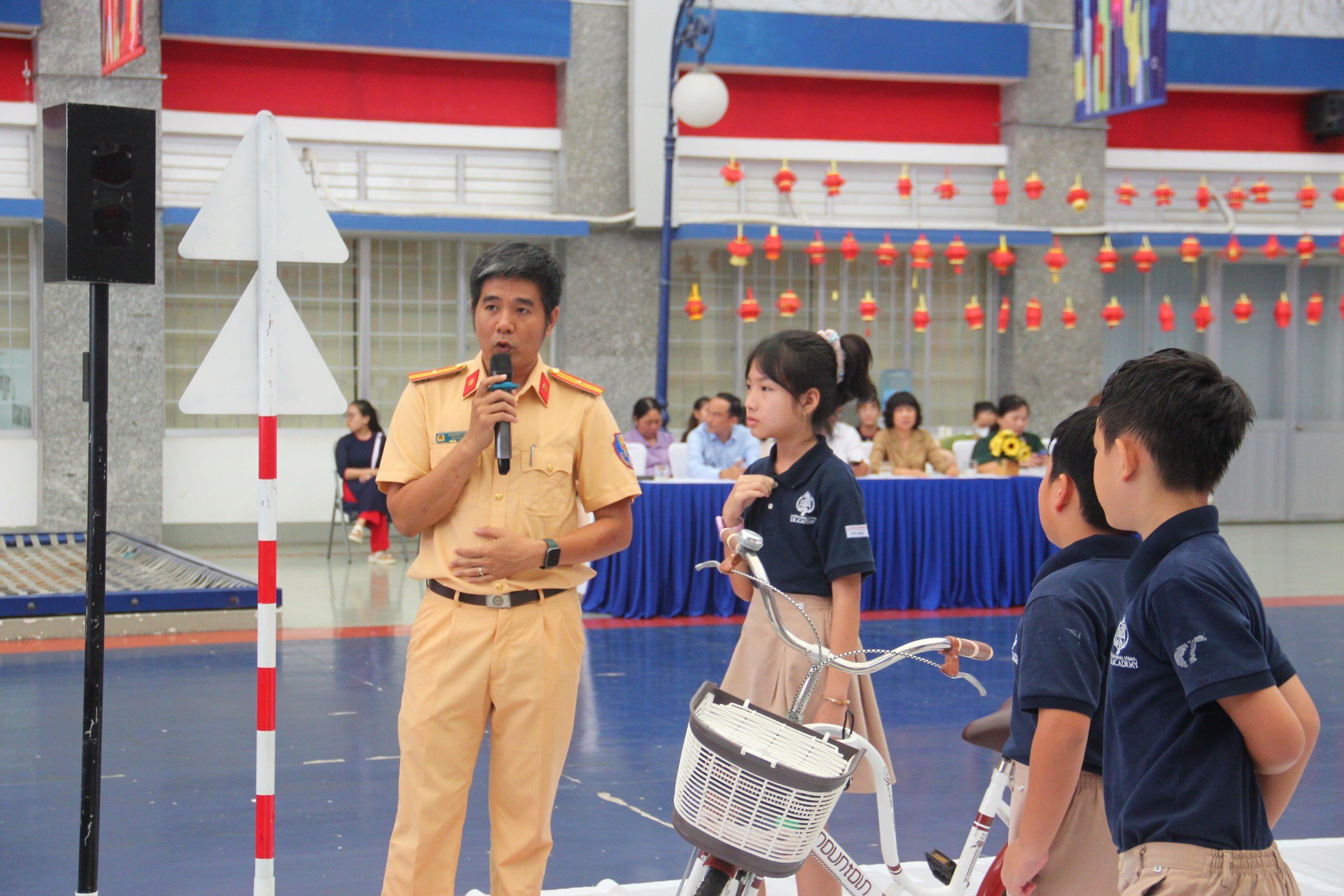 Thiếu tá Hoàng Bá Tuấn thuộc PC08 hướng dẫn kỹ năng đi xe đạp an toàn cho học sinh trường UK Academy.