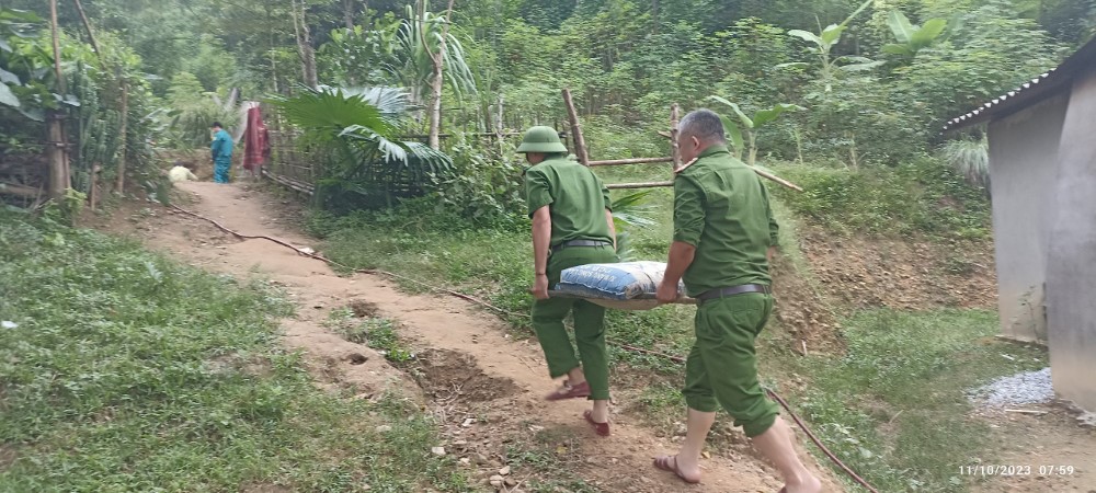 Cán bộ Công an huyện Tương Dương vận chuyển vật liệu để làm móng nhà cho người dân