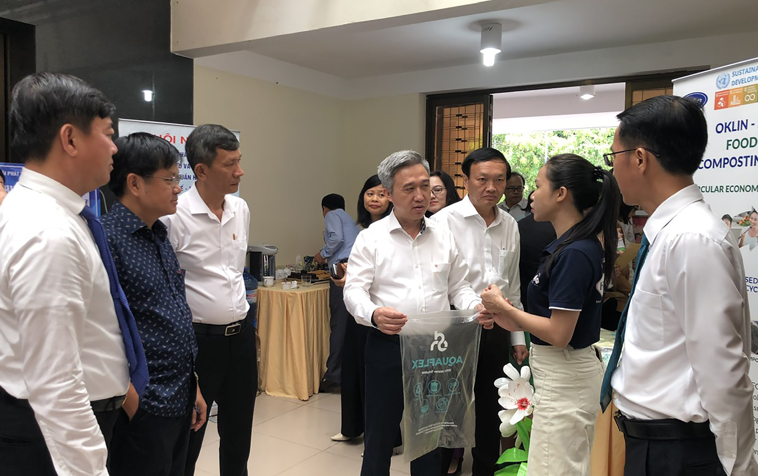 Ông Đặng Minh Thông, Phó Chủ tịch UBND tỉnh (ở giữa) và các đại biểu tham quan và nghe giới thiệu về các sản phẩm thân thiện với môi trường được trưng bày tại Hội nghị.
