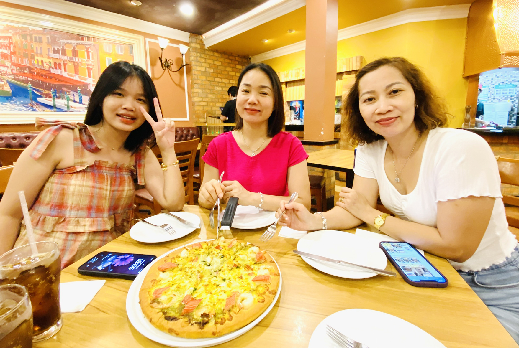 Chị Phạm Thị Kim Loan (giữa) cùng người thân thưởng thức pizza tại Pizza Company.