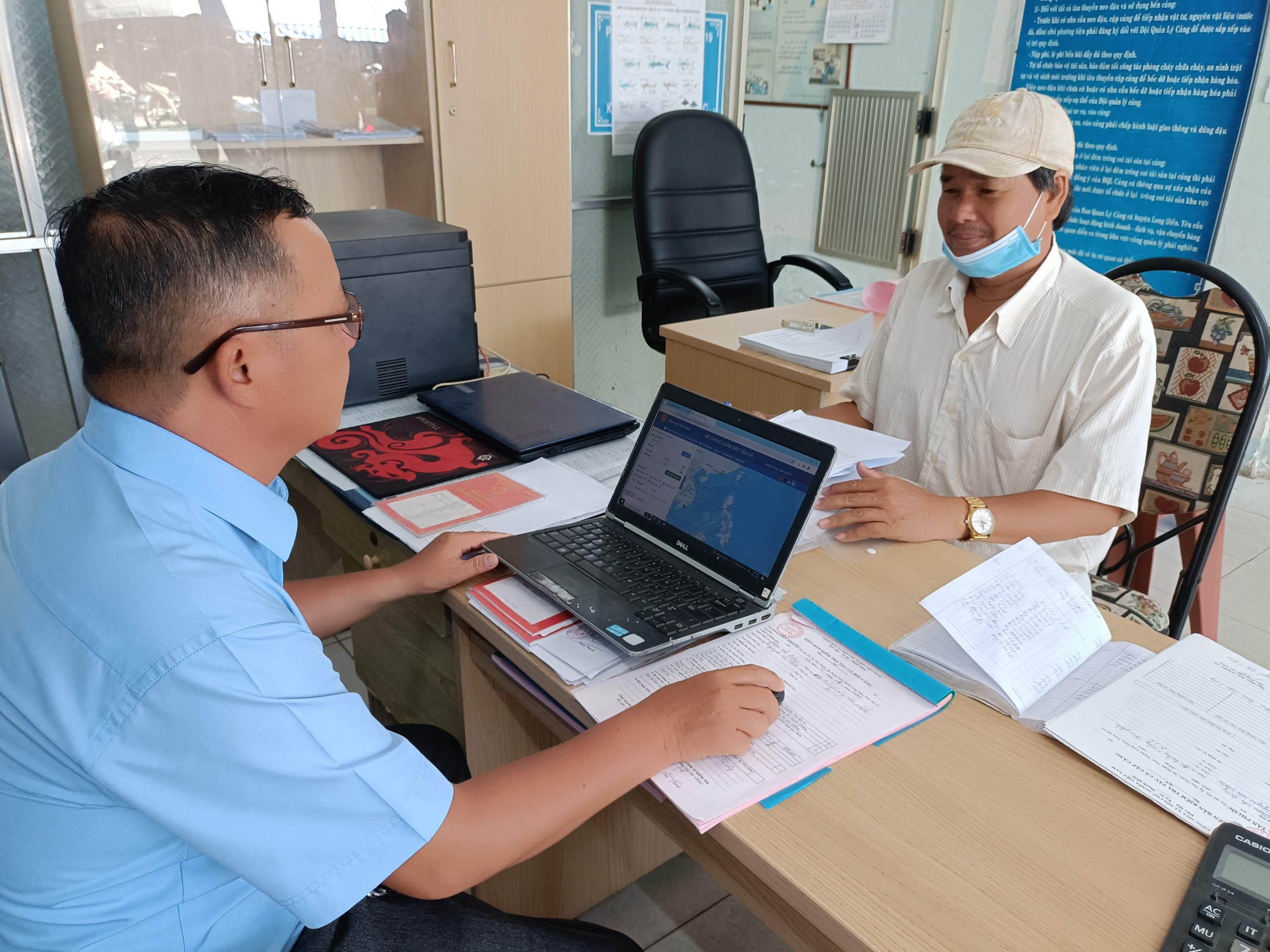 Nhân viên cảng cá Tân Phước (huyện Long Điền) kiếm tra giấy tờ, tọa độ, sản lượng hải sản khai thác theo nhật ký hành trình tàu cá khai báo.