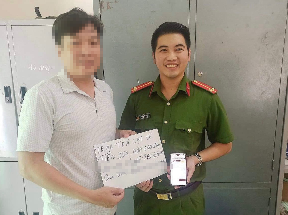 Trung úy Đỗ Duy Sơn, cán bộ Công an xã Tân Hải trả lại tiền cho người chuyển nhầm