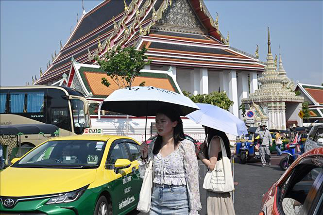 Người dân che dù tránh nắng nóng tại trên đường phố Bangkok, Thái Lan.