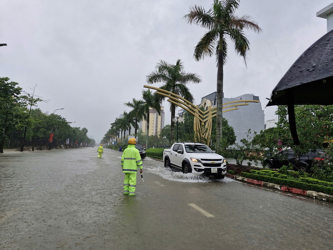 Đội CSGT - TT Công an thành phố Vinh phân luồng, điều tiết phương tiện, hướng dẫn, cảnh báo người dân và các phương tiện không đi vào chỗ nước sâu, đảm bảo an toàn cho người tham gia giao thông…
