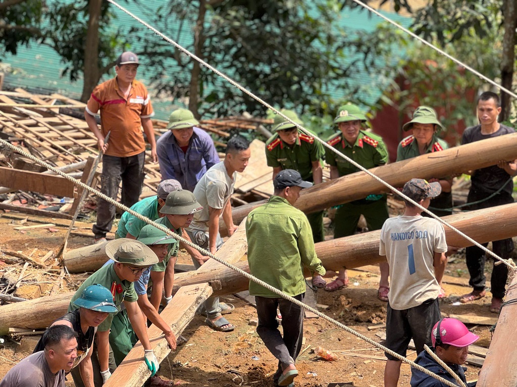 Cán bộ, chiến sĩ Công an tỉnh Nghệ An hỗ trợ người dân bản Xiêng Thù, xã Chiêu Lưu tháo nhà cửa di chuyển đến nơi an toàn 
