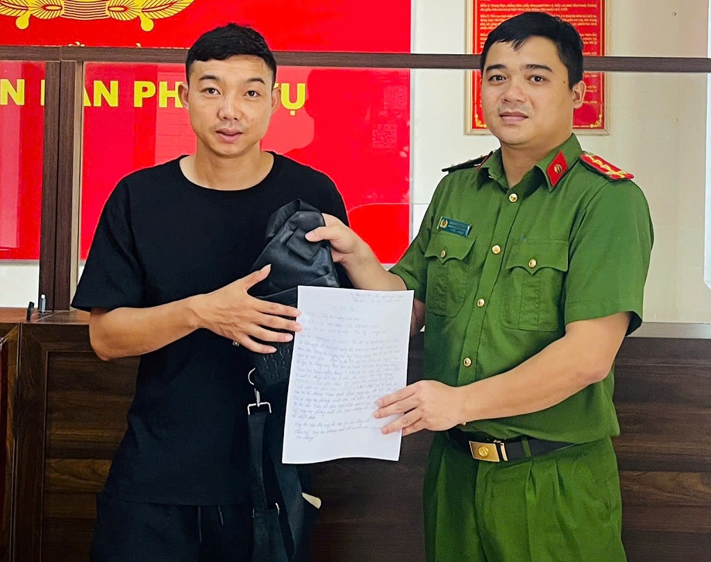 Đại úy Trần Nguyên Mạnh, cán bộ Công an phường Vinh Phú trao trả tài sản cho anh Công