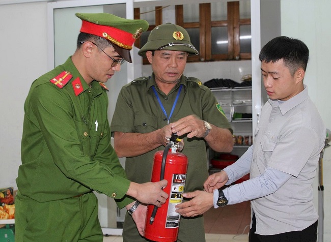 Lực lượng bảo vệ an ninh, trật tự ở cơ sở tham gia cùng Công an phường Trường Vinh hướng dẫn người dân sử dụng bình chữa cháy