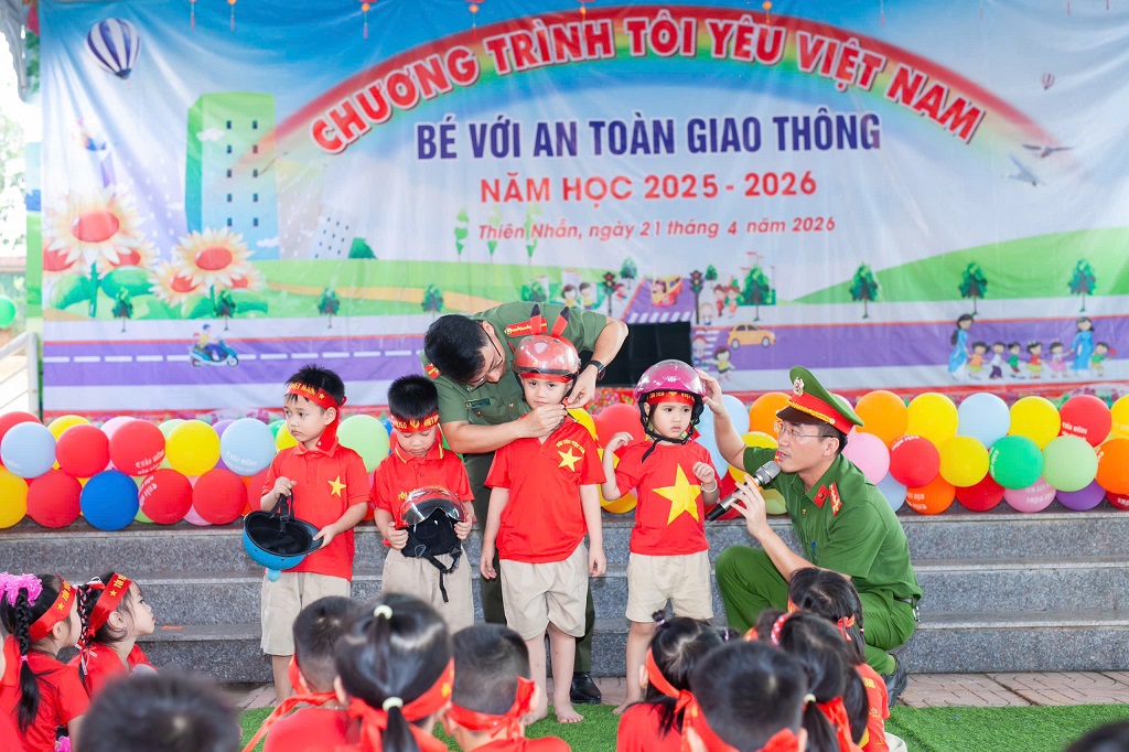 Công an xã Thiên Nhẫn hướng dẫn trẻ đội mũ bảo hiểm đúng cách 