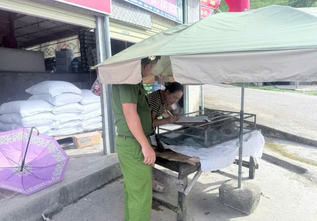 Công an xã Nậm Cắn nhắc nhở những hộ dân lấn chiếm lòng lề đường để kinh doanh