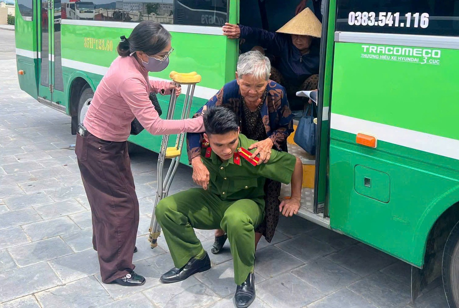 Công an xã Nghĩa Đồng hỗ trợ người già - là thân nhân liệt sĩ đến điểm thu nhận mẫu sinh phẩm ADN