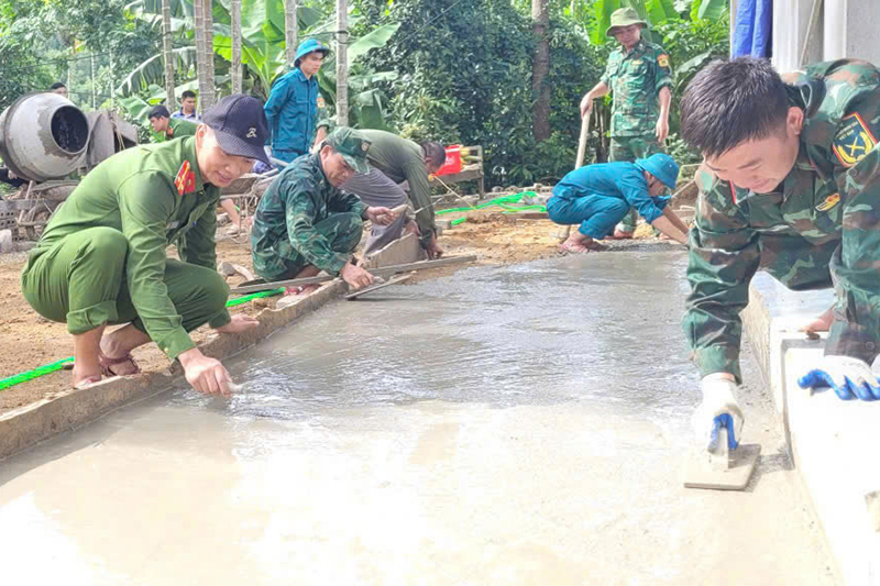 Công an xã tham gia ngày công hỗ trợ gia đình bà Lương Thị Lan xây dựng nhà
