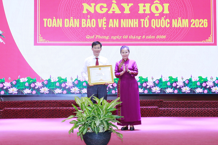 Đồng chí Võ Thị Minh Sinh trao Bằng khen của Chủ tịch UBND tỉnh tặng đồng chí Trương Minh Cương - Bí thư Đảng ủy xã Quế Phong vì đã có thành tích trong bảo vệ an ninh Tổ quốc