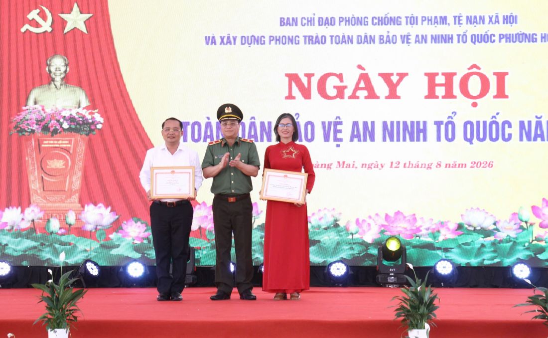 Đồng chí Thiếu tướng Đinh Việt Dũng, Ủy viên Ban Thường vụ Tỉnh ủy, Bí thư Đảng ủy, Giám đốc Công an tỉnh  trao Giấy khen của Giám đốc Công an tỉnh tặng Trường THPT Hoàng Mai và ông Phạm Văn Hào - Chủ tịch UBND phường Hoàng Mai