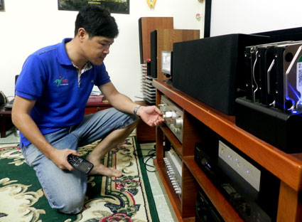 Anh Lê Đăng Khôi, căn chỉnh các thiết bị trong “rạp chiếu phim” tại nhà.