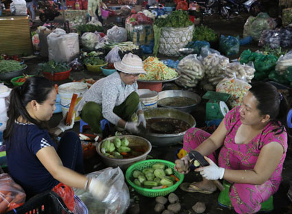 Một nhóm người được thuê gọt rau, củ tại chợ Bà Rịa.