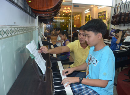 Anh Quốc Trung, chủ cơ sở dạy nhạc Suối Nhạc (302, Trương Công Định, TP.Vũng Tàu) dạy nhạc cho học viên.
