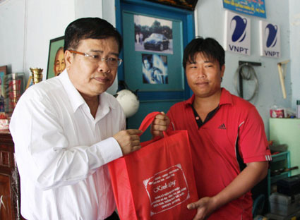 Ông Nguyễn Văn Trình, Phó Bí thư Tỉnh ủy, Chủ tịch UBND tỉnh, thăm tặng quà gia đình ông Lê Thành Cộng, nguyên đại tá quân đội. Ảnh: MINH THIÊN