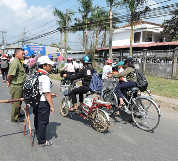 Thành viên Đội Sao đỏ Trường THCS Trương Công Định (xã châu pha, huyện tân thành) phối hợp với Công an xã phân luồng giao thông trước cổng trường. 