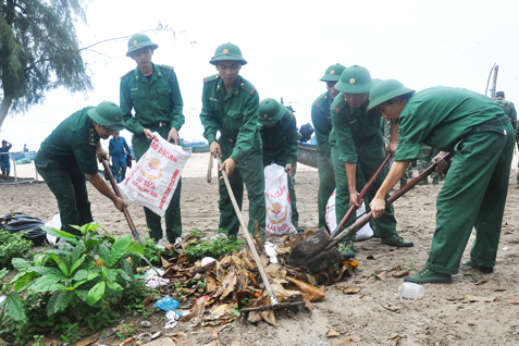 Cán bộ, chiến sĩ Đồn Biên phòng Phước Thuận thu gom rác ở ấp Hồ Tràm, xã Phước Thuận.