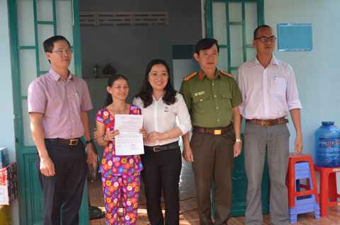 Chị Lê Thị Hằng (thứ hai từ trái sang) nhận quyết định bàn giao nhà “Mái ấm tình thương”.