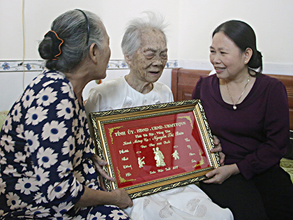 Đồng chí Nguyễn Thị Yến, Phó Bí thư Thường trực Tỉnh ủy, Trưởng Đoàn ĐBQH tỉnh tặng khánh vàng cho cụ Nguyễn Thị Biên (mẹ của liệt sĩ Hồ Văn Của), ở phường 3, TP. Vũng Tàu). Ảnh: BÙI HƯƠNG