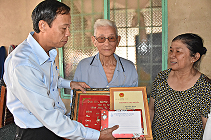 Đồng chí Nguyễn Văn Thọ, Ủy viên Ban Thường vụ Tỉnh ủy, Trưởng Ban Nội chính Tỉnh ủy trao Thiệp chúc Tết của Chủ tịch nước, khánh vàng mừng thọ và quà cho cụ Bùi Văn Thuận (xã Suối Nghệ, huyện Châu Đức). Ảnh: THÀNH HUY