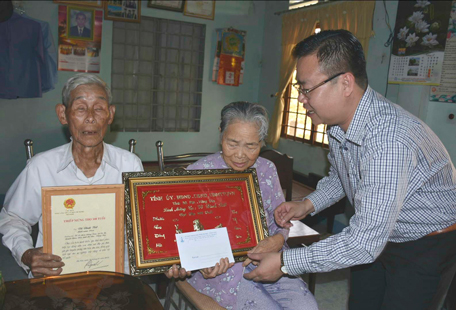 Đồng chí Nguyễn Văn Đồng, Ủy viên Ban Thường vụ Tỉnh ủy, Trưởng Ban Dân vận Tỉnh ủy trao khánh vàng và quà mừng thọ cho cụ Võ Đình Tiết, xã Cù Bị, huyện Châu Đức. Ảnh: ĐĂNG KHOA