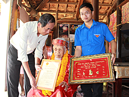 Ông Đoàn Văn Hai, Chủ tịch Hội Nông dân tỉnh trao thiệp mừng thọ của Chủ tịch nước cho vụ Hoàng Thỏn (xã Xuyên Mộc, huyện Xuyên Mộc). Ảnh: QUANG VINH