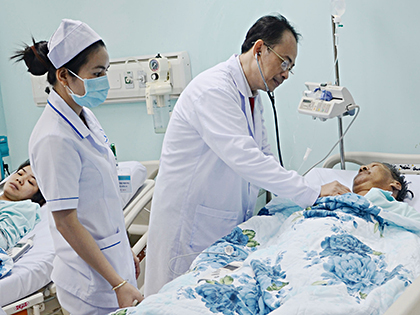 Bác sĩ kiểm tra tình trạng bệnh nhân sau khi phẫu thuật đặt ống thông catheter cố định tại vùng bụng.