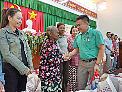 Ông Phạm Ngọc Hùng, Giám Đốc nhân sự Công ty Mychen trao quà cho bà con hộ nghèo thị trấn Ngãi Giao.