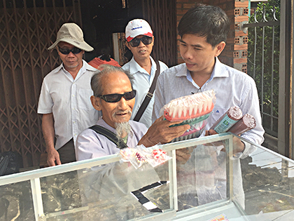 Hội viên Hội Người mù huyện Đất Đỏ bán bàn chải nhựa tại khu phố Thanh Tân, thị trấn Đất Đỏ, huyện Đất Đỏ.