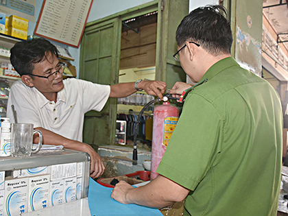 Kiểm tra kỹ năng sử dụng bình chữa cháy của một tiểu thương tại chợ Suối Nghệ (huyện Châu Đức).