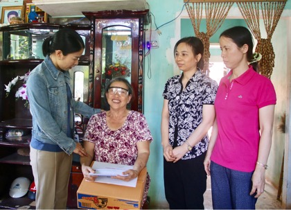 Các thành viên Ban Nữ công POS trao quà cho bà Nguyễn Thị Tấn - người khuyết tật - ở thôn Quảng Tây, xã Nghĩa Thành.