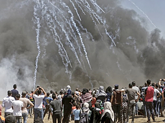  Người biểu tình Palestine đối mặt với hơi cay từ quân đội Israel tại ranh giới giữa Israel với Gaza ngày 14-5.