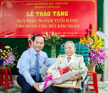 Đồng chí Mai Ngọc Thuận, Ủy viên Ban Thường vụ Tỉnh ủy, Bí thư Thành ủy, Chủ tịch HĐND TP.Vũng Tàu trao Huy hiệu 70 năm tuổi Đảng và tặng hoa chúc mừng đồng chí Bùi Kim Ngân (SN 1930, đảng viên Chi bộ 5, Đảng bộ phường 7).