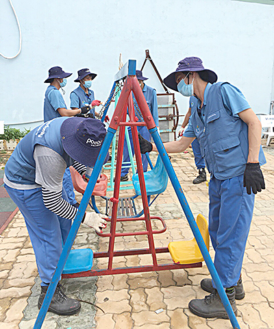 Công nhân Công ty TNHH Posco Việt Nam sửa chữa, sơn mới các dụng cụ vui chơi cho trẻ em ở Làng Posco Việt Nam (huyện Tân Thành).