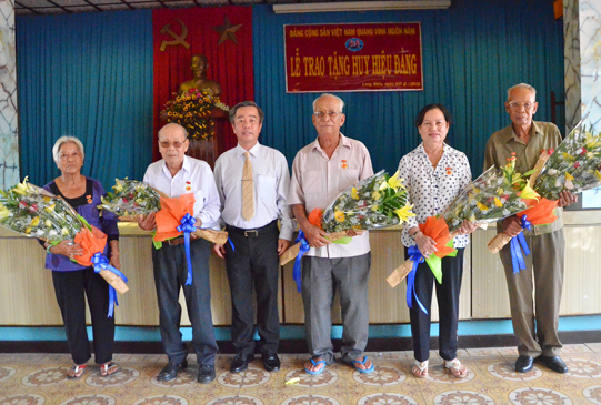 Đồng chí Võ Hữu Hạnh, Phó Bí thư Thường trực Huyện ủy, Chủ tịch HĐND huyện tặng hoa chúc mừng các đảng viên được tặng Huy hiệu Đảng.