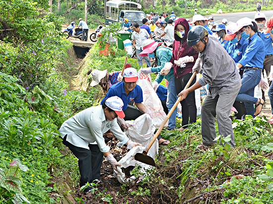 Cán bộ, công chức và đoàn viên, thanh niên khơi thông cống rãnh trên các tuyến đường của thị trấn Ngãi Giao. Ảnh: ĐINH HÙNG