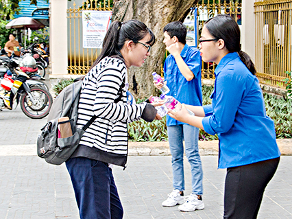 Đoàn viên, thanh niên đội tiếp sức mùa thi tặng nước uống cho các TS tại Hội đồng thi Trường THPT Châu Thành (TP.Bà Rịa). Ảnh: BẢO KHÁNH.