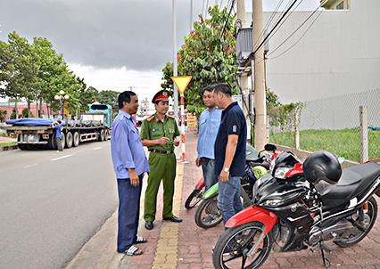 Đại úy Nguyễn Văn Lên, Cảnh sát khu vực Công an phường Phú Mỹ trao đổi thông tin về tình hình ANTT với các thành viên Đội xe ôm phòng chống tội phạm.  