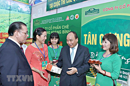 Thủ tướng Nguyễn Xuân Phúc xem gian hàng trưng bày sản phẩm tại hội nghị.