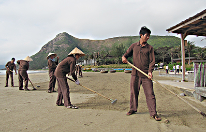 Nhân viên KDL Six Senses Côn Đảo sàng cát, làm sạch bãi tắm mỗi ngày.