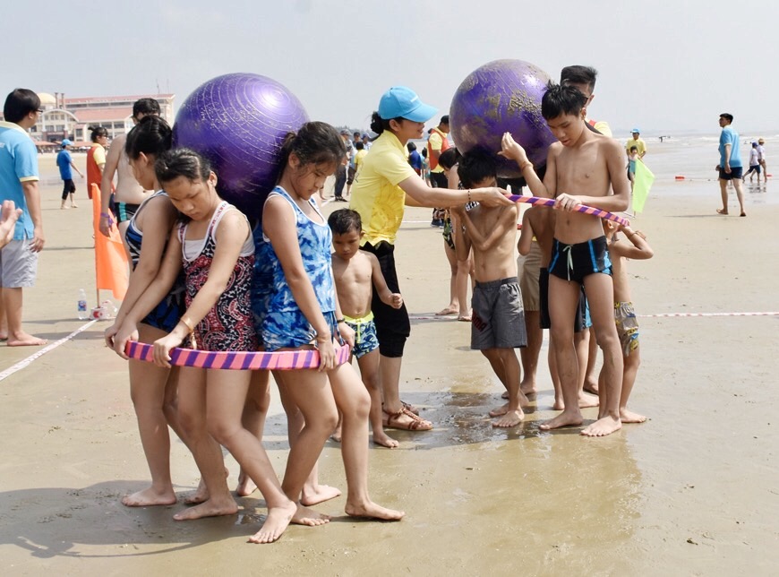 Các em tranh tài trong trò chơi cõng banh chạy đua.