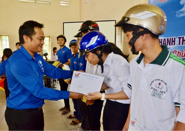 Anh Nguyễn Minh Triết, Phó Bí thư Tỉnh Đoàn, Phó Chủ tịch Thường trực Hội LHTN tỉnh trao quà cho HS có người thân mất do tai TNGT.