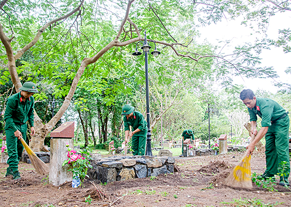 Cán bộ, chiến sỹ lực lượng vũ trang huyện Côn Đảo dọn dẹp vệ sinh trên các phần mộ liệt sỹ.