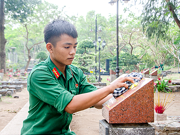 Chiến sỹ lau chùi bia mộ liệt sỹ.